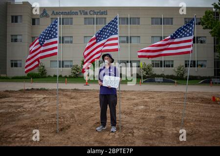Manhattan, Kansas, USA. Mai 2020. STEVE BREWER, steht gegenüber von Ascension Via Christi Hospital mit einem Schild, das lautet, Health Heroes, machte zu danken lokalen Gesundheitshelfer am Dienstag. Der 190. Luftbetankungsflügel der Kansas Air National Guard flog um 13:13 Uhr über Manhattan, KS, um Gesundheitsarbeiter, Ersthelfer und andere Frontmitarbeiter im Kampf gegen COVID-19 zu begrüßen. Die Operation Kansas Strong startete in Emporia, KS, und flog über Manhattan, Lawrence und Topeka, KS. Kredit: Luke Townsend/ZUMA Wire/Alamy Live News Stockfoto