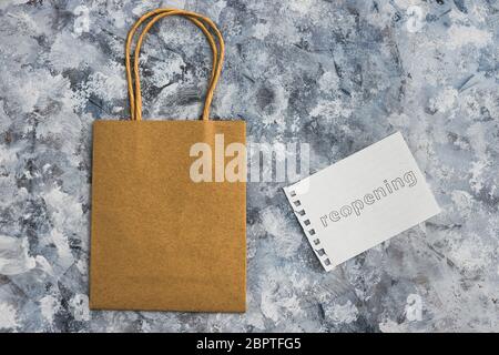 Wiedereröffnung von Geschäften nach der Virus-Pandemie Covid-19, Einzelhandel Einkaufstasche mit Wiedereröffnung Memo Stockfoto