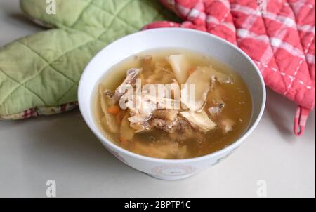 Chinesische traditionelle amerikanische Ginseng-Suppe mit Hühnerknochen in einer Schüssel serviert. Draufsicht. Stockfoto