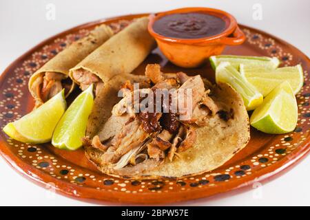 Mexican Carnitas Tacos ist traditionelle Schweinefleisch Taco mit Mais-Tortilla und Sauce in Mexiko-Stadt auf weißem Hintergrund Stockfoto