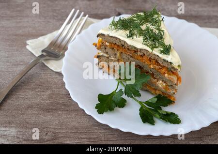 Leberkuchen in einem Teller auf einem Holztisch. Snack aus Leberpfannkuchen und Gemüse Stockfoto