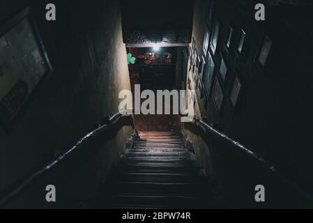 Dramatische Sicht auf die unheimlich Treppen von oben in die Dunkelheit des Inneren des alten Pubs Stockfoto