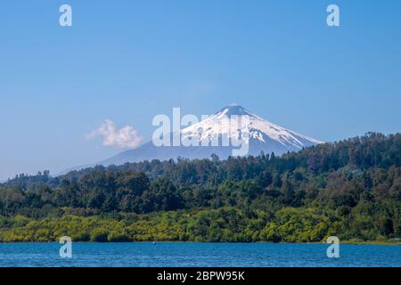 Vulkan Villarrica mit schneebedeckter Spitze vor blauem Himmel. Blick vom Villarrica See in der Pucon Stadt. Chile Stockfoto