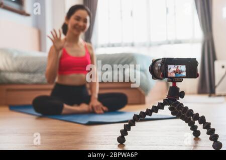 Kamera, die Video und live von Asiatin Yoga von zu Hause aus im Schlafzimmer, wenn Covid19 Ausbruch, gesunde oder Meditation Übung, Coronavirus pa Stockfoto