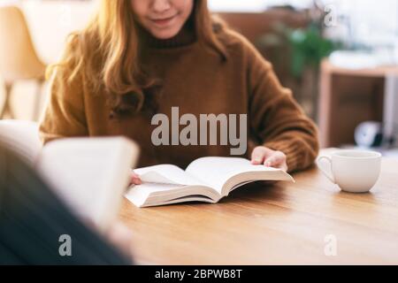 Gruppe von Menschen sitzen und Genossen zusammen lesen Buch auf hölzernen Tisch Stockfoto