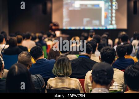 Rückansicht des asiatischen Publikums, der mit dem Sprecher auf der Bühne im Seminarkonferenzraum oder im Konferenzsaal, in der Ausbildung und im Workshop spricht, Stockfoto
