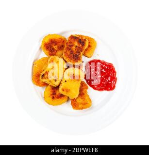 Draufsicht auf viele gebratene Hühnernuggets mit Tomatenketchup auf weißem Teller isoliert auf weißem Hintergrund Stockfoto