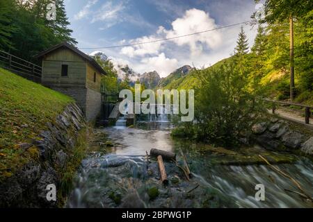 Kleiner Wasserfall auf einem Bach, der aus dem See Laghi di Fusine in den Julischen Alpen in Italien fließt Stockfoto