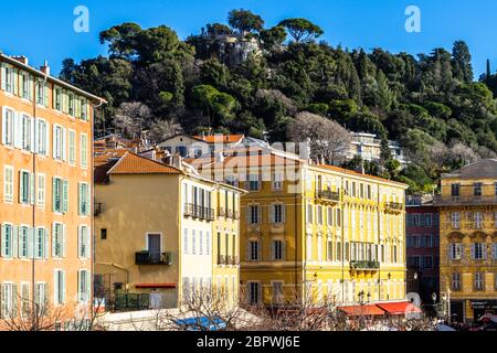 Nizza, Frankreich, Januar 2020 - Traditionelles, farbenfrohes Gebäude von Cours Saleya unter der Colline du Chateau (Burgberg), dem besten Aussichtspunkt von Nizza Stockfoto