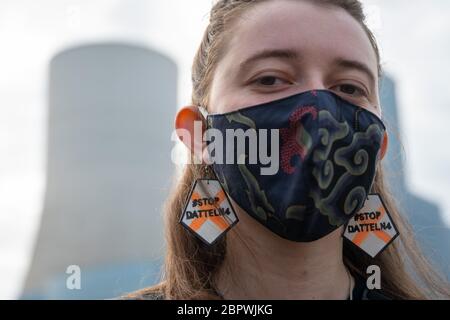 Datteln, Deutschland. Mai 2020. Ein Umweltschützer demonstriert mit bunten Ohrringen mit der Aufschrift 'Stopp Datteln 4' und einem Mund-Nase-Schutz vor dem Kohlekraftwerk Datteln 4 das Kohlekraftwerk im nördlichen Ruhrgebiet ist zum Symbol der energiepolitischen Debatte der Bundesregierung geworden. Der Betreiber Uniper hat zu seiner Jahreshauptversammlung eingeladen. Quelle: Bernd Thissen/dpa/Alamy Live News Stockfoto