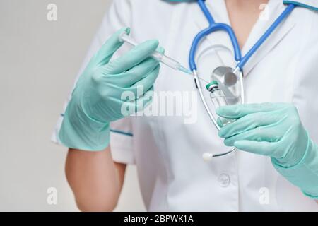 Medizinische Facharbeiterin wählt den Impfstoff in eine Spritze Stockfoto