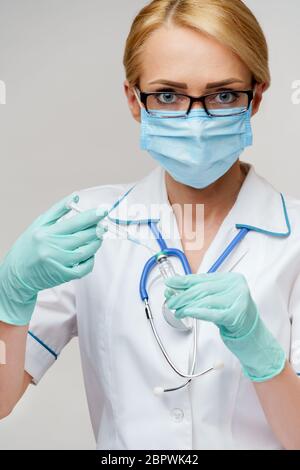 Medizinische Facharbeiterin wählt den Impfstoff in eine Spritze Stockfoto
