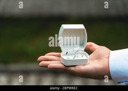 Schachtel mit einem Ehering in der Hand beim Mann Stockfoto