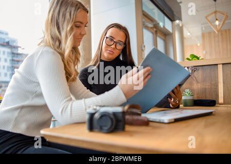 Zwei Weibliche Blogger Diskutieren Über Veröffentlichung Im Magazin Cafe Stockfoto