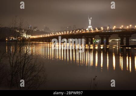 Nachtansicht der Brücke über den breiten Fluss Dnipro in Kiew auf einer langen Belichtung Stockfoto