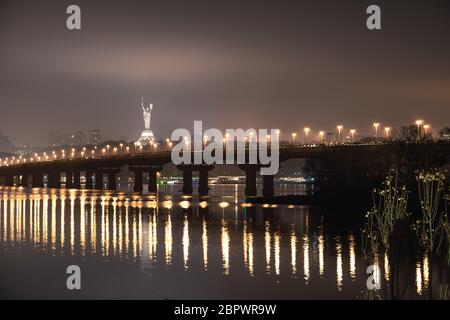 Nachtansicht der Brücke über den breiten Fluss Dnipro in Kiew auf einer langen Belichtung Stockfoto