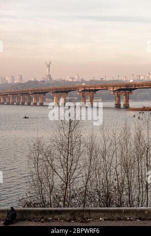 Breiter Fluss Dnjeper mit einer Brücke nach Sonnenaufgang mit schönen Wolken Stockfoto