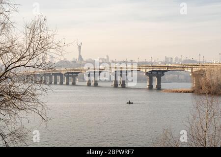 Breiter Fluss Dnjeper mit einer Brücke nach Sonnenaufgang mit schönen Wolken Stockfoto