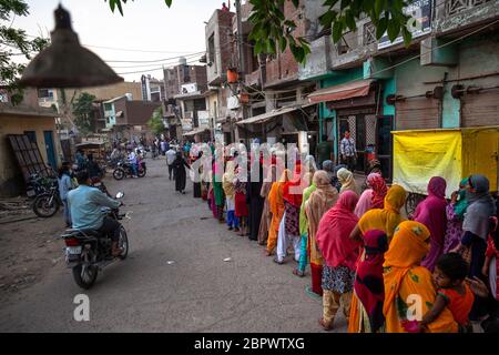 Indische Frauen warten in der kürzlich von Unruhen betroffenen Region Mustafabad in der Schlange, um kostenlose Lebensmittel zu erhalten, als das Land am 14. Mai 2020 in Neu-Delhi, Indien, seine Lockdown-Beschränkung lockert. Die Region Mustafabad gehörte zu den am schlimmsten betroffenen Gebieten, als im Februar in Indiens Hauptstadt Unruhen ausbrachen, weil ein umstrittenes Gesetz zur Änderung der Staatsbürgerschaft von der Regierung der Bharatiya Janata Partei verabschiedet wurde. Mehrere Familien, die wegen Brandstiftung durch Randalierer obdachlos waren, kümmern sich nun um sich selbst inmitten einer landesweiten Sperre, die von der Regierung auferlegt wurde, um die Ausbreitung des Coronavirus im CO einzudämmen Stockfoto