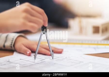 Ein Architekt mit Kompass zu zeichnen und Shop Zeichnung im Büro messen Stockfoto