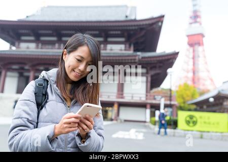 Frau benutzt Handy im Tokyo Tower Stockfoto