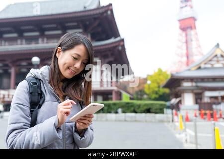 Frau Verwendung von Handys in Tokio Stockfoto