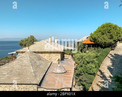 Heiliges Berg Athos. Klostergebäude mit orangefarbenen Fliesen vor dem Hintergrund des Meeres bedeckt Stockfoto