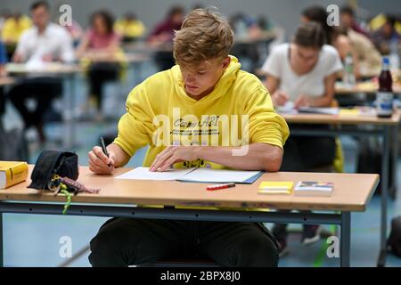 Ravensburg, Deutschland. Mai 2020. Ein Schüler schaut sich die Aufgaben während der deutschen Abschlussprüfung in der Sporthalle des Albert-Einstein-Gymnasiums an; auf seinem Kapuzenpullover steht: 'Corona hAbi - daheim geblieben, noch bekommen. Rund 80 Schüler absolvieren die Deutschprüfung am Albert-Einstein-Gymnasium. Quelle: Felix Kästle/dpa/Alamy Live News Stockfoto