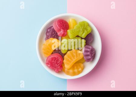 Grütze Bonbons in Schüssel auf farbigen Hintergrund. Stockfoto