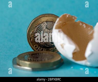 Ethisch bezog Wildvogeleierschale schoss nah oben mit britischen Pfundmünzen, einer zwei-Pfund-Münze und ungefähr 50 Pence Stücke. Stockfoto