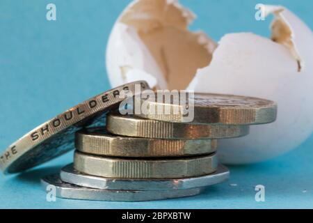 Ethisch bezog Wildvogeleierschale schoss nah oben mit britischen Pfundmünzen, einer zwei-Pfund-Münze und ungefähr 50 Pence Stücke. Stockfoto