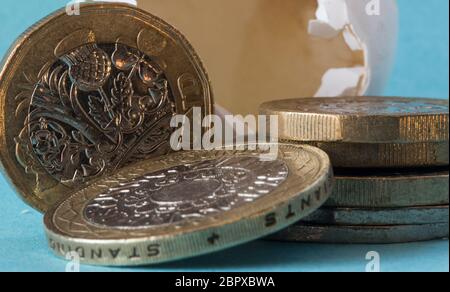Ethisch bezog Wildvogeleierschale schoss nah oben mit britischen Pfundmünzen, einer zwei-Pfund-Münze und ungefähr 50 Pence Stücke. Stockfoto
