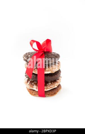 Stapel sortierter, original nürnberger Lebkuchen, Lebkuchen mit roter Schleife und Band isoliert auf weißem Hintergrund. Stockfoto