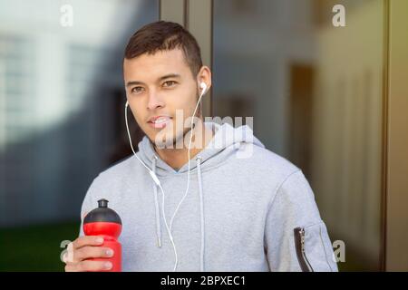 Trinkwasser junger Mann Läufer laufen Suchen denken Jogging Sport Training Fitness im Freien Stockfoto