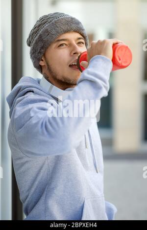 Sport Ausbildung junger Latin man Trinkwasser suchen denken Hochformat runner Outdoor Stockfoto