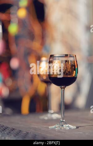 Wein Glas und Ostereier im verschwommenen Hintergrund. Frühling Ostern Konzept. Stockfoto