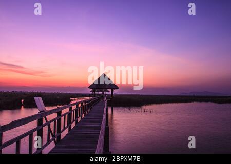 Hölzerne Brücke in Lotus See Sonnenuntergang pünktlich am Khao Sam Roi Yot National Park, Thailand Stockfoto