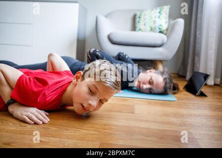 Kleiner Junge zusammen mit seiner Mutter Yoga zu Hause während der Quarantäne Stockfoto