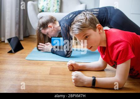 Kleiner Junge zusammen mit seiner Mutter Yoga zu Hause während der Quarantäne Stockfoto