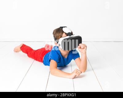 Coole und schöne Junge mit roten Hosen und blaue T-Shirt ist mit virtuellen 3D-Brille zu Hause Stockfoto