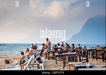 Touristen versammeln sich, um den Sonnenuntergang im Las Cabanas Beach Resort Café, El Nido, Palawan, den Philippinen zu genießen und zu fotografieren. Stockfoto