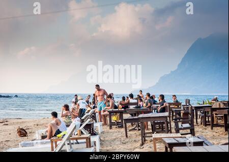 Touristen versammeln sich, um den Sonnenuntergang im Las Cabanas Beach Resort Café, El Nido, Palawan, den Philippinen zu genießen und zu fotografieren. Stockfoto