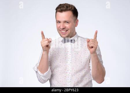 Aufgeregt jungen Kerl Heben seinen Zeigefinger nach oben. Studioaufnahme Stockfoto