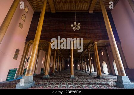 Blick auf die Holzarchitektur und Muster von Säulen im Inneren des berühmten Jama Masjid in der Stadt Srinagar in Kaschmir Stockfoto