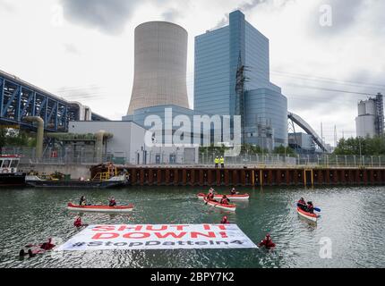 20. Mai 2020, Nordrhein-Westfalen, Datteln: Greenpeace-Aktivisten schwimmen im Wasser des Dortmund-Ems-Kanals vor dem Kohlekraftwerk Datteln 4 und halten ein Transparent mit den Worten "Halt es ab - Stopp Datteln 4", während andere Demonstranten ihnen in Booten folgen. Das angrenzende Kohlekraftwerk Datteln 4 im nördlichen Ruhrgebiet ist zum Symbol des Streits um die Energiepolitik der Bundesregierung geworden. Das Kraftwerk des Düsseldorfer Energieunternehmens Uniper soll im Sommer endgültig ans Netz gehen. Der Betreiber Uniper hat eine Online-Einladung zu seiner jährlichen ausgestellt Stockfoto