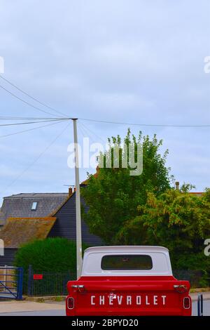 Ein klassisches Retro rot-weiß Chevrolet Pick-up-Truck Vintage Allradantrieb Fahrzeug Chevy vor traditionellen englischen Kent County Häuser geparkt Stockfoto