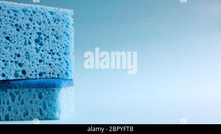 Zwei blaue Schwämme zum Waschen und Löschen von Schmutz, die von Hausfrauen im Alltag verwendet werden. Sie bestehen aus porösem Material wie Schaum. Waschmittelreten Stockfoto