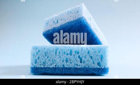 Zwei blaue Schwämme zum Waschen und Löschen von Schmutz, die von Hausfrauen im Alltag verwendet werden. Sie bestehen aus porösem Material wie Schaum. Waschmittelreten Stockfoto