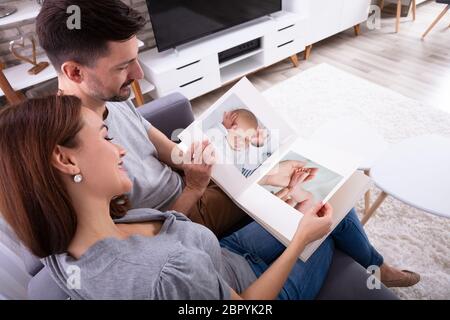 In der Nähe von Paar an Baby's Fotoalbum suchen In Stockfoto