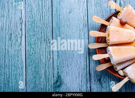 Gruppe von hausgemachten Vanille Eis am Stiel auf eine rustikale Holz Hintergrund Stockfoto